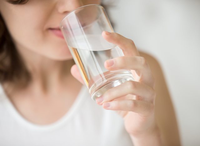 Femeie care bea apă. Cum evită oamenii care trăiesc mai mult sa se ingrase.